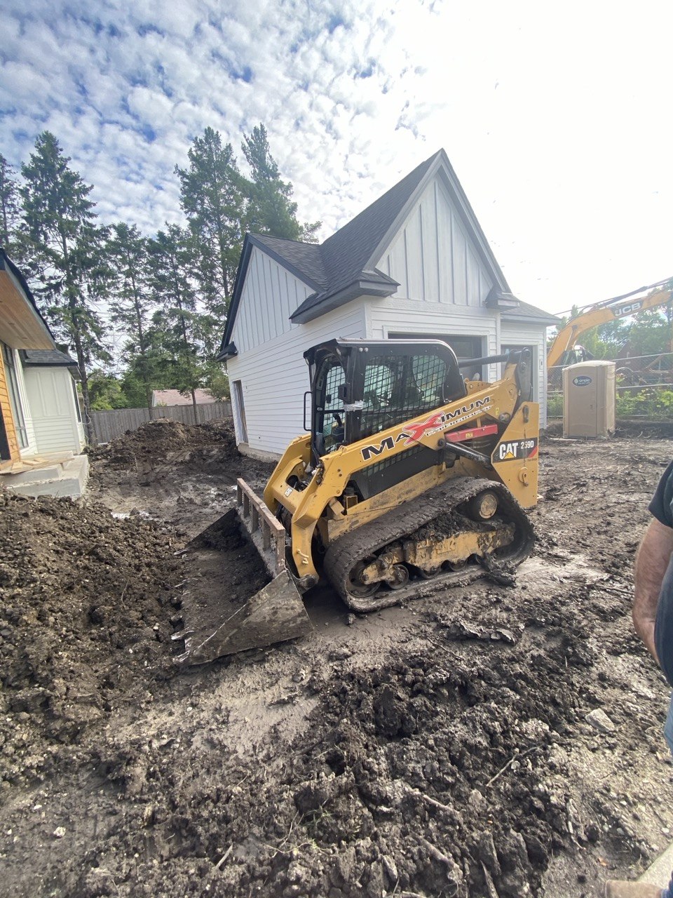 CAT skid steer with MAXIMUM branding grading at construction site